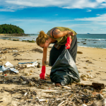 Woman picking up litter on a beach